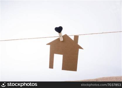 Little paper house attached to a string with a heart clip