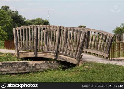 Little Pedestrian Curved Wooden Bridge in a Park