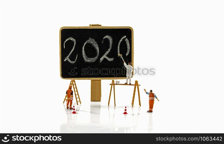 little people working at the new 2020 letters to paint them on a donkey. painting the new year 2020