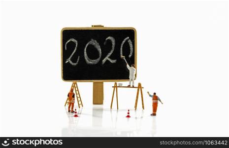 little people working at the new 2020 letters to paint them on a donkey. painting the new year 2020