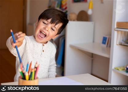 Little preschooler kid drawing with coloured pencils. Homeschooling. Learning community. Montessori school.