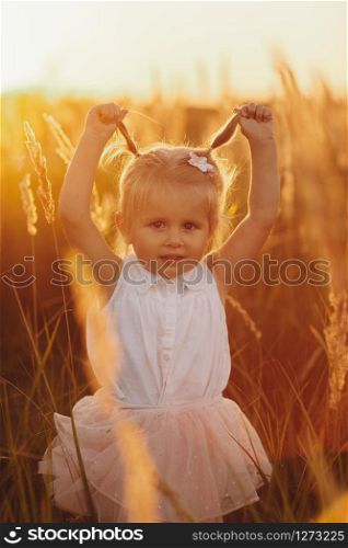 little pretty girl in the field. little girl with two tails. Cute baby girl 3-4 year old close up. Summer time. Childhood.. Cute baby girl 3-4 year old close up. Summer time. Childhood. little girl with two tails. little pretty girl in the field