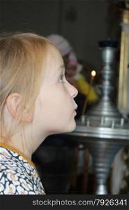 Little pretty girl praying in the church. Little girl praying in the church