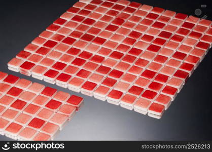 little red ceramic tile on a grey background with reflection, majolica. for the catalog. square small tile