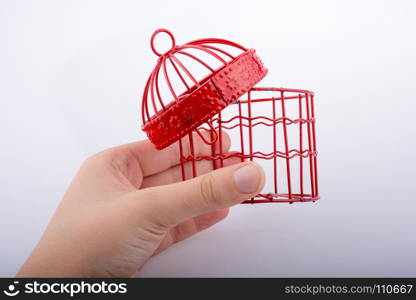 Little red color bird house with metal bars on a white background