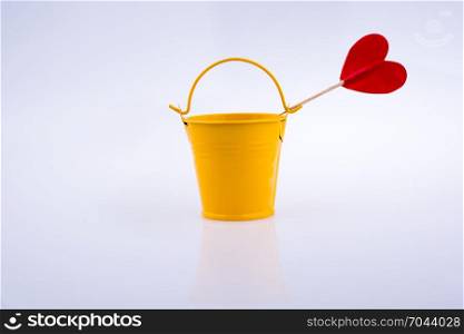 Little red color heart shape and yellow color bucket