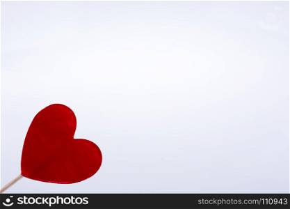 Little red color heart shape at the top of a stick