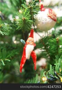 Little santa claus, sitting in a plastic christmas tree