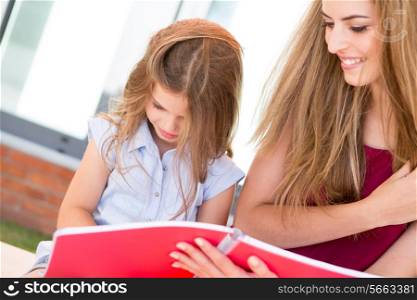 Little school girl showing sketchbook to her mother