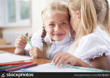 Little school girls sharing secrets