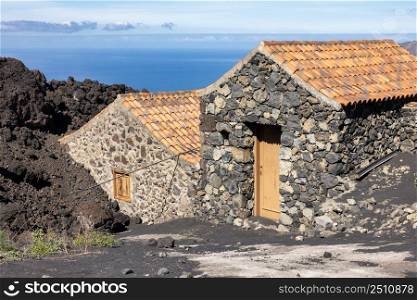 Little shed been spared while partial covered by new lava field from recent erupted volcano Cumbre Vieja at la Palma. Shed partial covered by lava from volcano at la Palma
