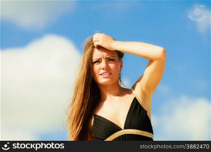 Little shocked woman on beach. Long hair girl model blue sky.
