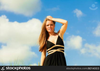 Little shocked woman on beach. Long hair girl model blue sky.