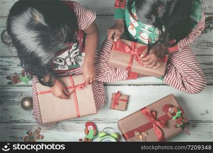 Little sisters opening their gifts on Christmas day