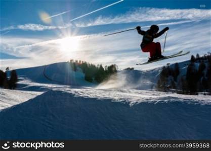 Little skier performs jump in the snow in ski slope