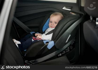 Little smiling baby on back seat