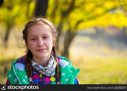 little smiling girl at the autumn park