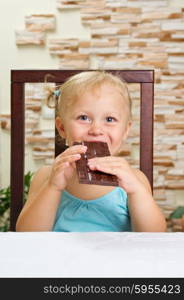 Little smiling girl with chocolate at light room