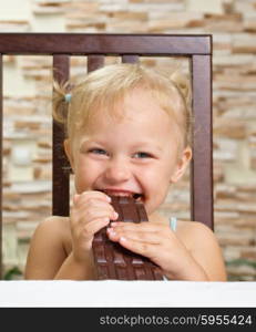 Little smiling girl with chocolate at light room