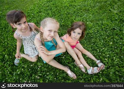 little smiling girls girlfriends on the green grass. children's holidays