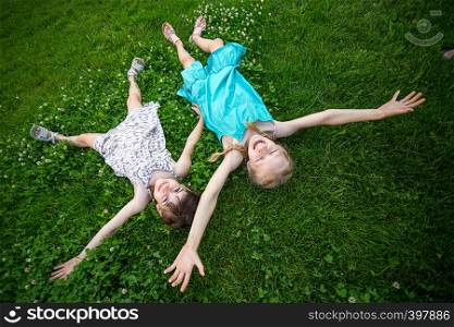 little smiling girls girlfriends on the green grass. children's holidays