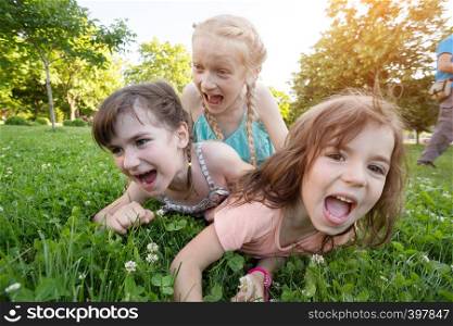 little smiling girls girlfriends on the green grass. crazy kids