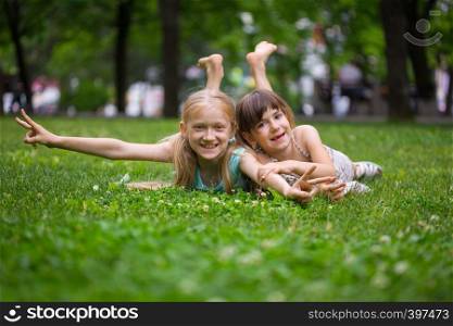 little smiling girls girlfriends on the lawn