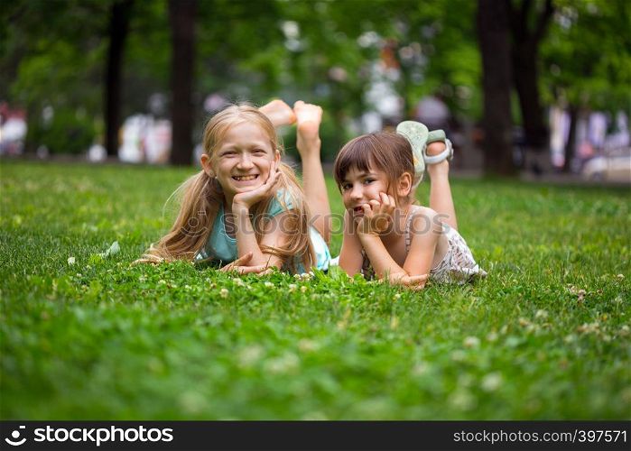 little smiling girls girlfriends on the lawn
