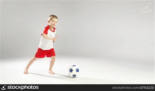 Little talented boy playing soccer