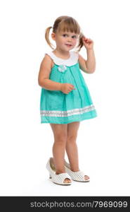 Little three year old girl in her mother&rsquo;s shoes in the studio on a white background.