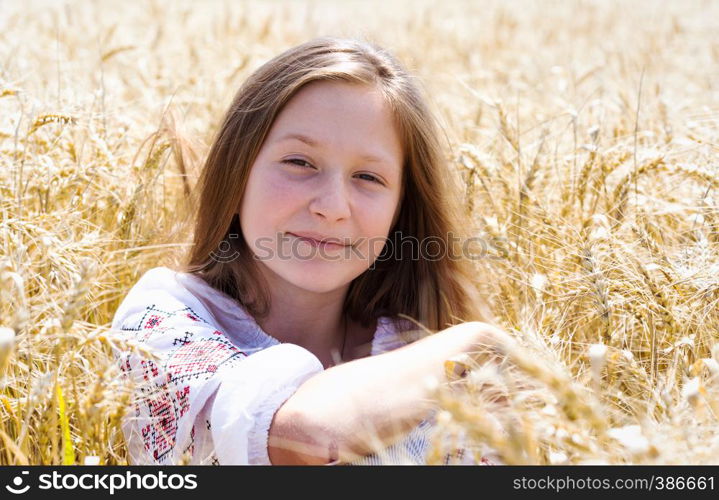 little ukrainian smiling girl in a wheat field