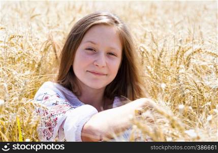little ukrainian smiling girl in a wheat field