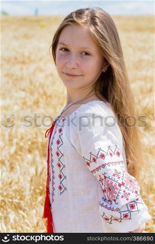 little ukrainian smiling girl in a wheat field