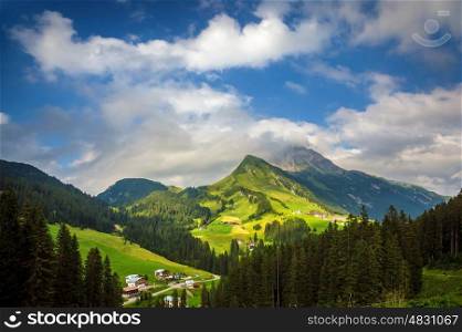 Little village in the mountains, fresh green valley, traditional mountainous buildings, Alps, Europe, summer vacation, travel and tourism concept&#xA;