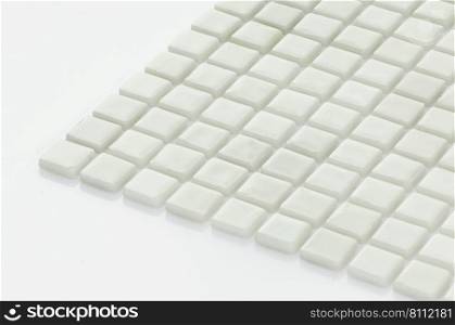little white ceramic tile on a light background, majolica. for the catalog. square small tile