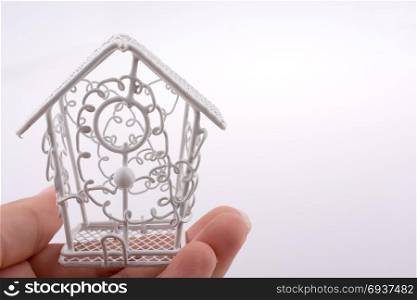 Little white metal bird house made of meta in handl