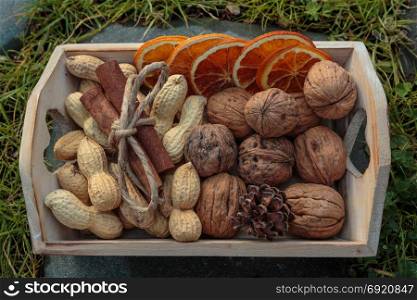 Little Wooden Box with Walnuts, Groundnut Seeds, Cinnamon Sticks and Dehydrated Orange Slices
