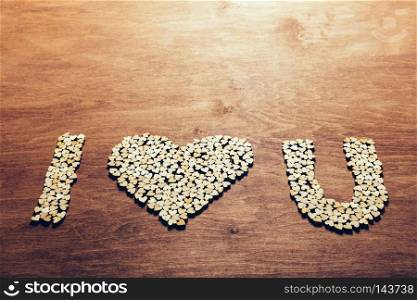 Little wooden hearts arranged into I  HEART  U writing on wooden background. Love concept. Valentine s Day.