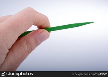 Little wooden sharp stick in hand on white background