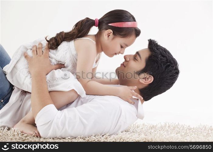 Little young girl sitting on father&rsquo;s stomach
