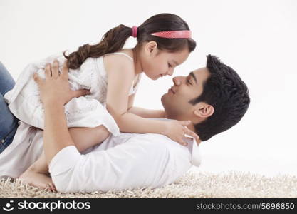 Little young girl sitting on father&rsquo;s stomach