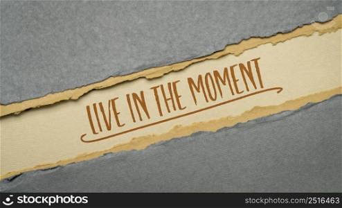 live in the moment inspirational quote - handwriting on a handmade paper in earth tones, diagonal web banner