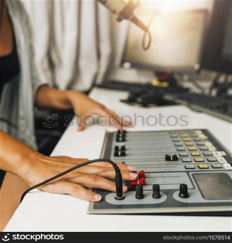 Live streaming from the studio, technician adjusting control board sliders. Live Streaming from the Podcast Studio