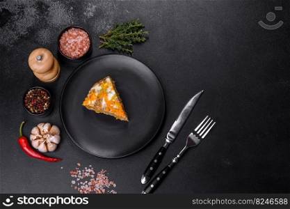 Liver cake with meat and egg, healthy protein food, rustic style. Delicious fresh liver cake with mayonnaise and carrots on a black plate against a dark concrete background