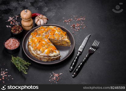 Liver cake with meat and egg, healthy protein food, rustic style. Delicious fresh liver cake with mayonnaise and carrots on a black plate against a dark concrete background