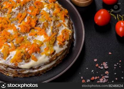Liver cake with meat and egg, healthy protein food, rustic style. Delicious fresh liver cake with mayonnaise and carrots on a black plate against a dark concrete background