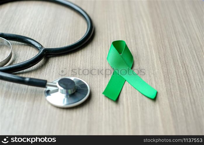 Liver Cancer Awareness, green Ribbon with stethoscope for supporting people living and illness. Healthcare and World cancer day concept