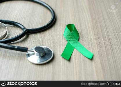 Liver Cancer Awareness, green Ribbon with stethoscope for supporting people living and illness. Healthcare and World cancer day concept
