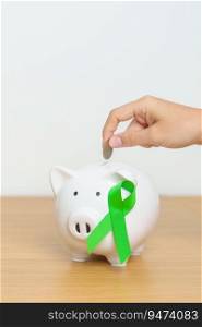 Liver, Gallbladders, bile duct, cervical, kidney Cancer and Lymphoma Awareness month, green Ribbon with Piggy Bank for support illness life. Health, Donation, Charity, Campaign, Money Saving, Fund 