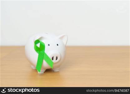 Liver, Gallbladders, bile duct, cervical, kidney Cancer and Lymphoma Awareness month, green Ribbon with Piggy Bank for support illness life. Health, Donation, Charity, Campaign, Money Saving, Fund 